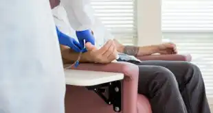 enfermeira realizando punção para quimioterapia em paciente com câncer