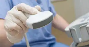 mão de médico com aparelho de ultrassom para realizar exame em paciente com coronavírus