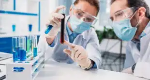 médicos laboratoristas avaliando tubo com sangue em point-of-care testing