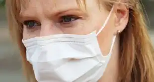Mulher usua máscara para se previnir durante a pandemia de Covid-19 em uma cidade que tentou instalar cabines de desinfecção.