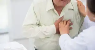 idoso com a mão no coração antes de sofrer morte súbita relacionada a covid-19
