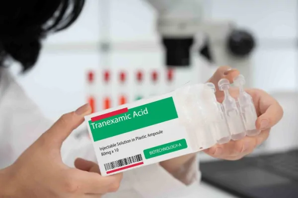 Profissional de saúde manipulando caixa de ácido tranexâmico